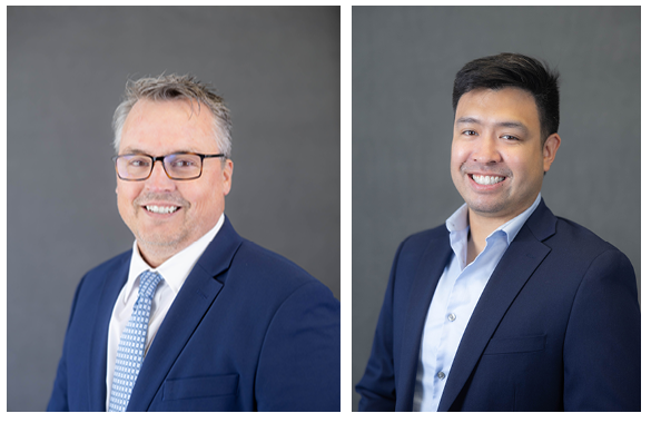 Two businessmen in navy suits posing for corporate headshots against a gray backdrop.