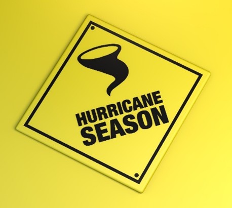 Tilted yellow warning sign with a hurricane funnel icon and the text 'HURRICANE SEASON' on a bright yellow background, conveying warning awareness.